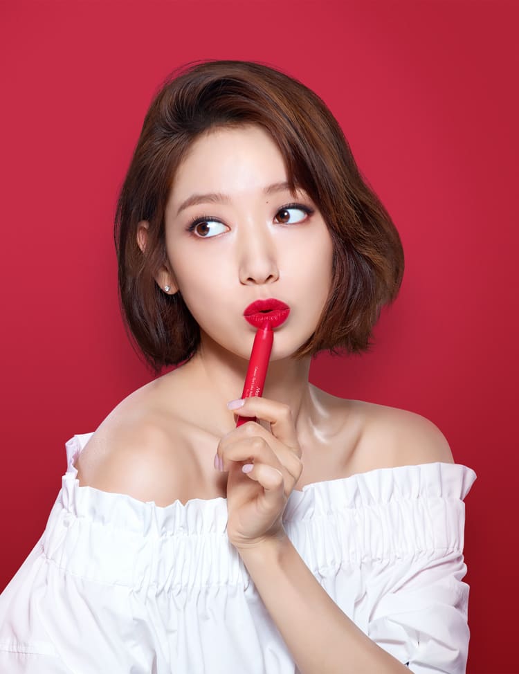 크리미 틴트 컬러 밤 인텐스 제품을 입술에 바르고, 한 손에 제품을 들고 있는 박신혜 모델컷