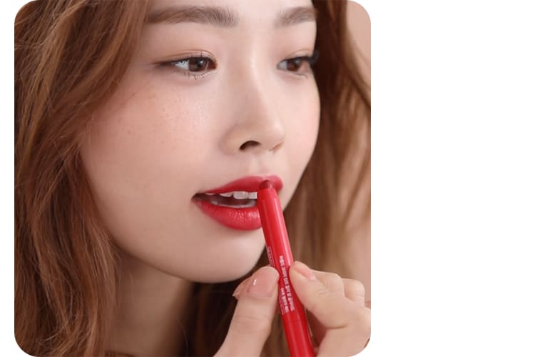 크리미 틴트 컬러밤 글라이드 제품을 윗입술에 바르는 모델의 모습