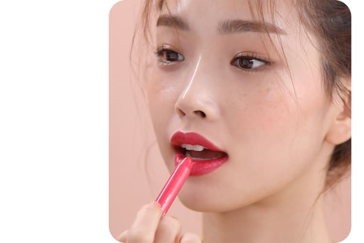 크리미 틴트 컬러밤 글라이드 제품을 아래 입술에 바르는 모델의 모습