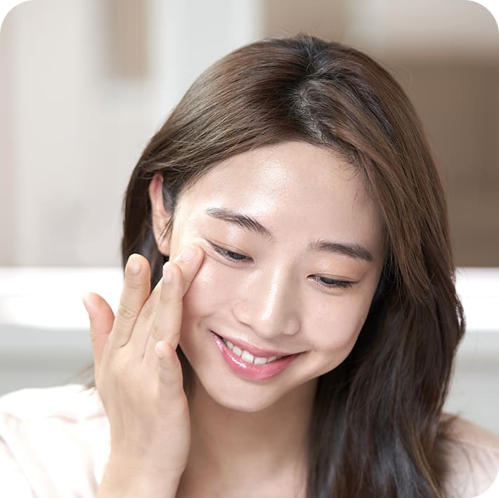 플로랄 하이드로 앰플토너를 눈가 주위에 바르면서 웃고 있는 모델