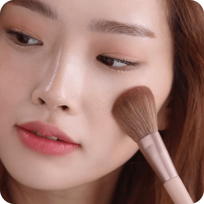 플라워 팝 블러셔를 브러쉬로 볼에 바르고 있는 모델
