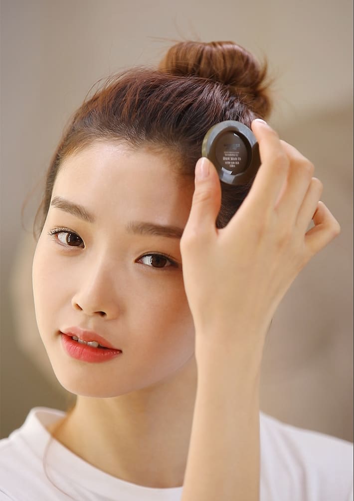 모델이 헤어퍼프로 제품을 바르며 앞머리 라인을 정리하고 있는 연출컷