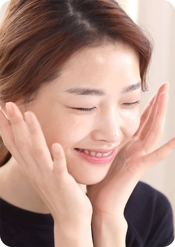 제품을 양 볼에 바르며 웃고 있는 모델